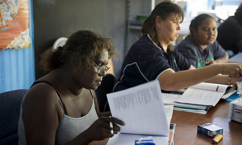 A middle aged indigenous women paper documents in an office
